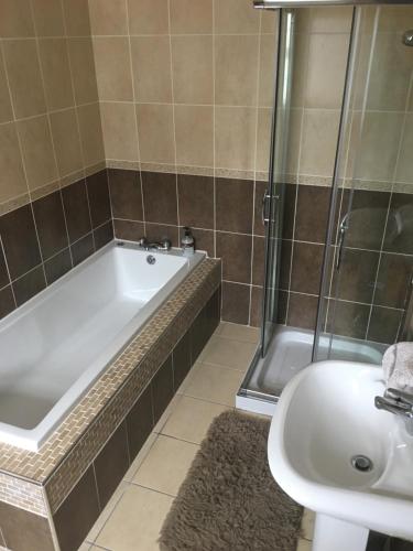 a bathroom with a bath tub and a sink at Drumhouse Guesthouse in Knock