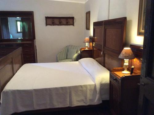 Marano sul PanaroにあるLa Furbera B&Bのベッドルーム(白いベッド1台、椅子付)