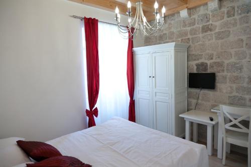 - une chambre avec un lit doté d'un rideau rouge et d'une fenêtre dans l'établissement Apartments Zoro, à Dubrovnik