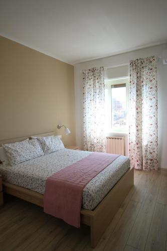 a bedroom with a large bed and a window at L'Alba sui Templi in Agrigento