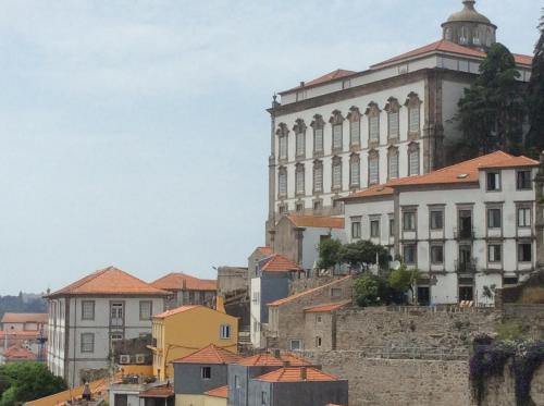 a large building with a clock on it's side at Arco Apartments in Porto