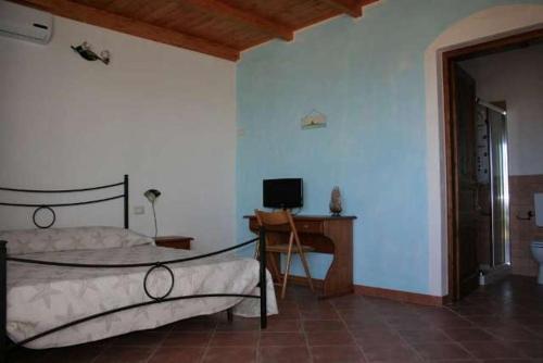 a bedroom with a bed and a desk with a computer at La Tankitta Turismo Rurale in Stintino