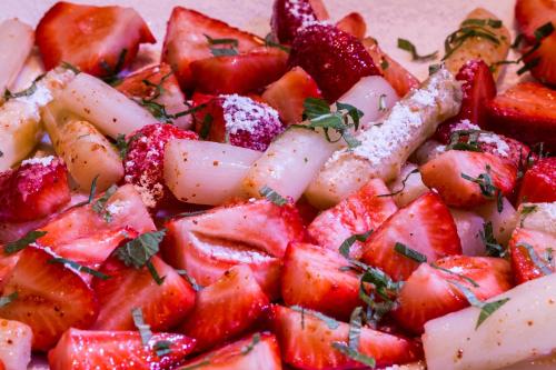 a plate of strawberries with powdered sugar on it at Historik Hotel Garni Christinenhof in Hameln