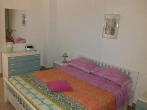 カステルサルドにあるAppartamento Bouganvilleのベッドルーム1室(ベッド1台、ドレッサー、鏡付)