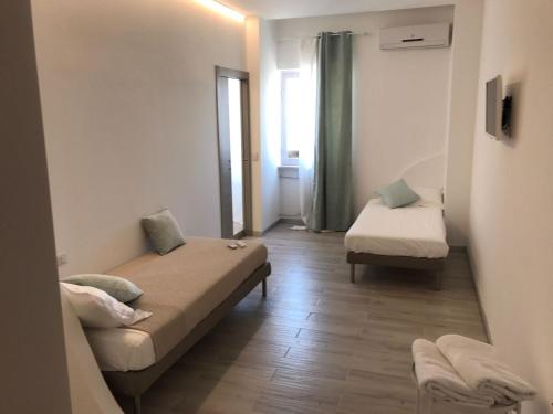 Habitación pequeña con 2 camas y ventana en B&B Piazza Marconi en Manfredonia