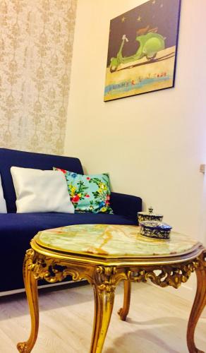 a gold coffee table in front of a blue couch at Navona Residenza de Charme in Rome
