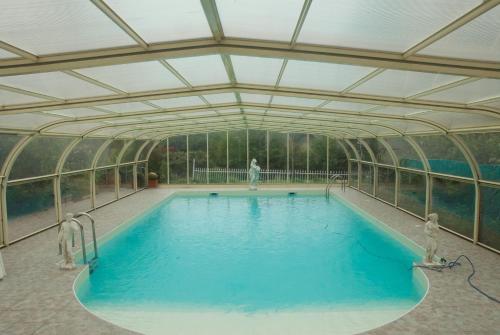 an indoor swimming pool with a glass ceiling at Le Clos des Cèdres b&b in La Rochefoucauld
