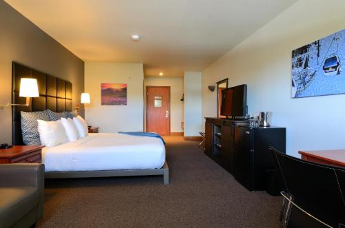 a hotel room with a bed and a flat screen tv at Wood River Inn & Suite in Hailey