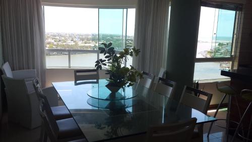 a dining room table with a vase of flowers on it at Apartamento em Tramandaí in Tramandaí