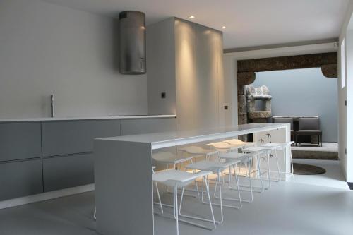 a kitchen with white tables and white stools at Quinta das Lavandeiras - Caldas de Vizela in Vizela