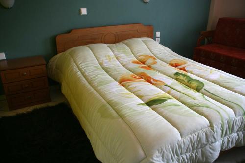 a bed with a white comforter on it in a bedroom at Guesthouse Mitsiopoulou in Neochori