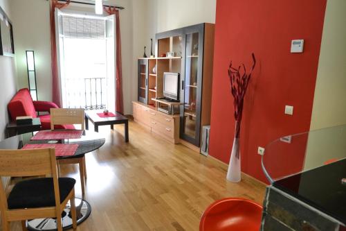 a living room with a red wall and a dining room at Alameda San Lorenzo Loft in Seville
