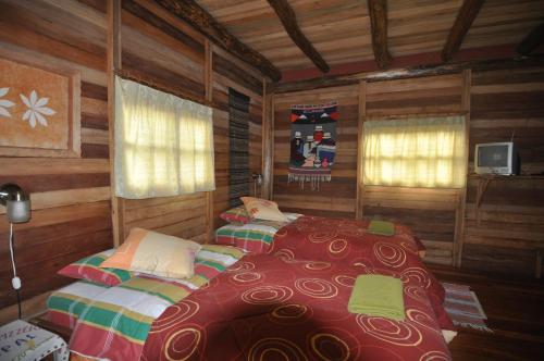 a bedroom with two beds in a log cabin at Kopal in Baeza