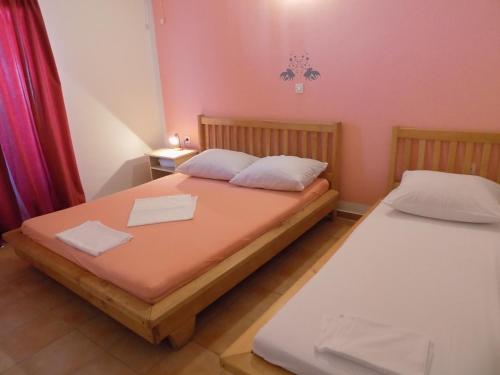 two twin beds in a room with pink walls at Apartment Lopar 25 in Lopar