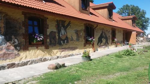 a building with paintings on the side of it at Kuldkaru Manor in Valaste
