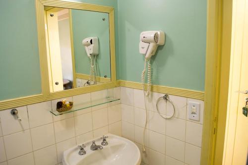 a bathroom with a sink and a phone on the wall at Pousada Vila das Cores in Campos do Jordão