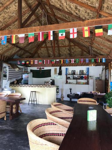 a dining room with tables and chairs and flags at Villa Paradise - Bukit Lawang in Bukit Lawang