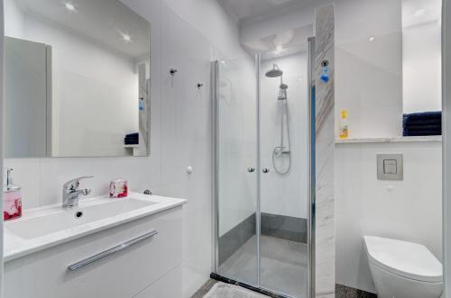 a bathroom with a shower and a sink and a toilet at Apartament Sopocki in Sopot