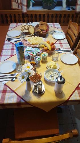 Una mesa con comida y platos encima. en Penzion Pr' Betel, en Jesenice