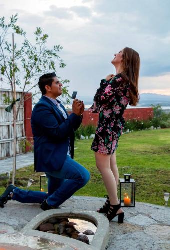 a man taking a picture of a woman standing next to a fountain at View Hotel Boutique in San Miguel de Allende