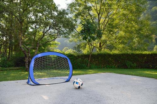 a blue tennis racket and a soccer ball on the ground at Apartment Sotočje in Dolenja Trebuša