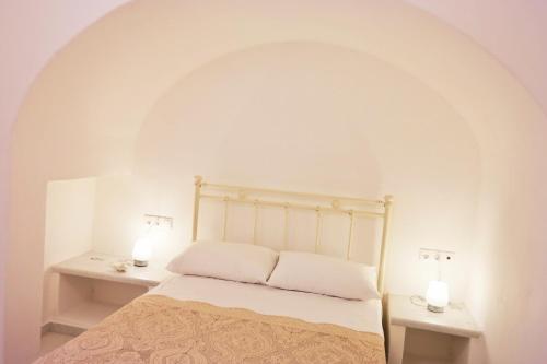 1 dormitorio con 1 cama con 2 lámparas en 2 mesas en Katerina Suites en Naxos