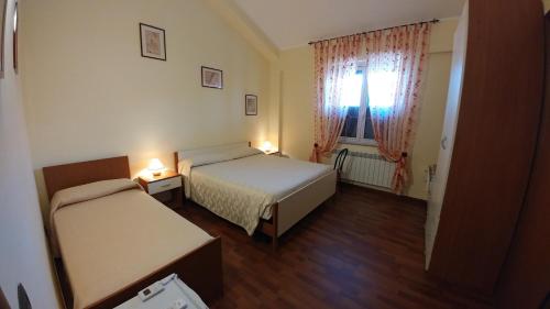 mały pokój z 2 łóżkami i oknem w obiekcie Bruno B&B w mieście Cropani