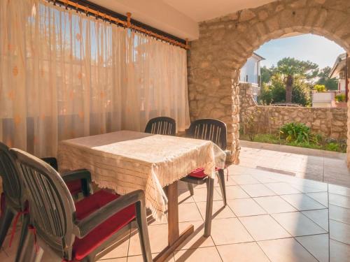 a dining room with a table and chairs on a patio at Apartments in Mali Losinj 14985 in Mali Lošinj