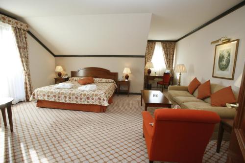 a hotel room with a bed and a couch at Gran Hotel Balneario De Puente Viesgo in Puente Viesgo