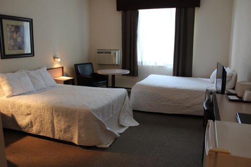 Ένα ή περισσότερα κρεβάτια σε δωμάτιο στο Motel Capri & Suites