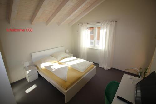Habitación blanca con cama y ventana en Choralm-Blick, en Brixen im Thale