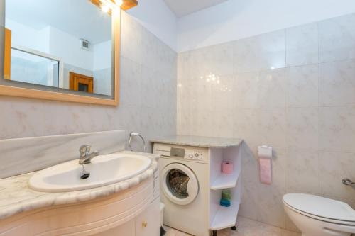 a bathroom with a sink and a washing machine at Cal Ginés in Llimiana
