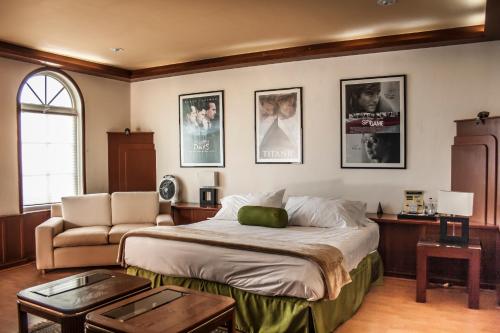 a bedroom with a bed and a chair and pictures on the wall at Hotel Esmeralda in Atlixco