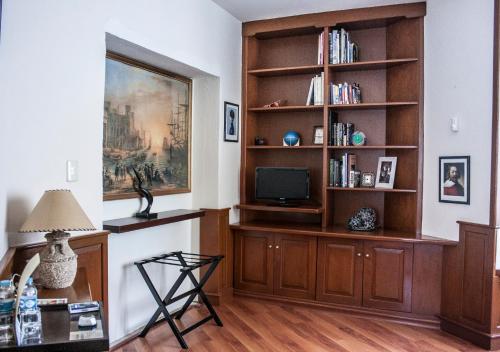 a living room with a tv and a book shelf at Hotel Esmeralda in Atlixco