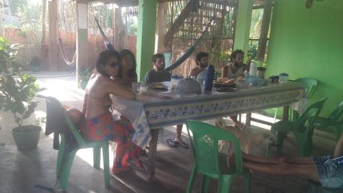 un groupe de personnes assises à une table dans l'établissement hospedaria pingo de ouro, à Atins