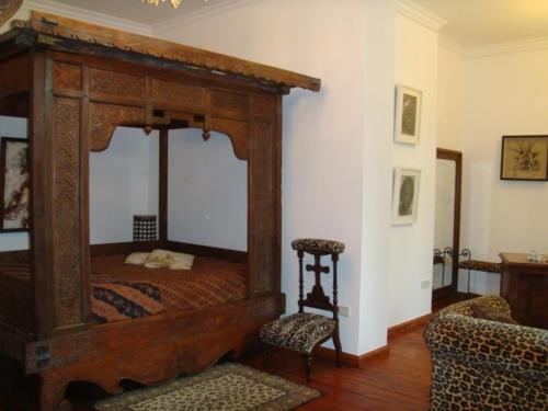 ein Schlafzimmer mit einem Himmelbett und einem Stuhl in der Unterkunft Residenz Villa Kult in Berlin