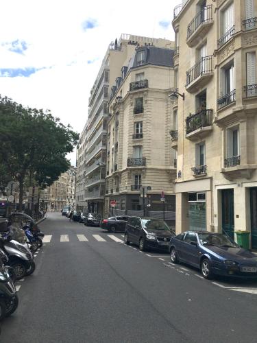 a city street with cars parked in front of buildings at Red Flat Paris in Paris
