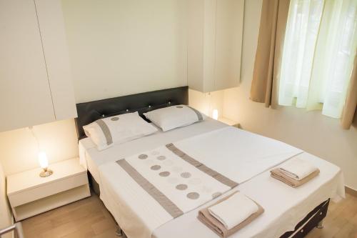 - une chambre dotée d'un grand lit avec des draps et des oreillers blancs dans l'établissement Apartments Villa Matea, à Žaborić