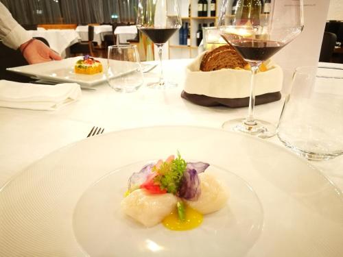 a plate of food on a table with wine glasses at Style Hotel Grifone in Madonna di Campiglio