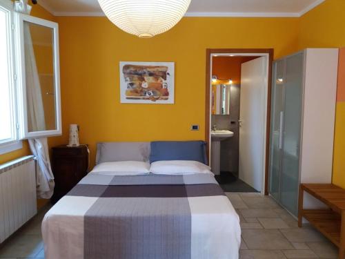 ein Schlafzimmer mit einem Bett in einem gelben Zimmer in der Unterkunft Casa Maria Teresa in Cannero Riviera