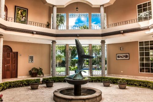 a statue in the lobby of a building with a fountain at Hotel Esmeralda in Atlixco