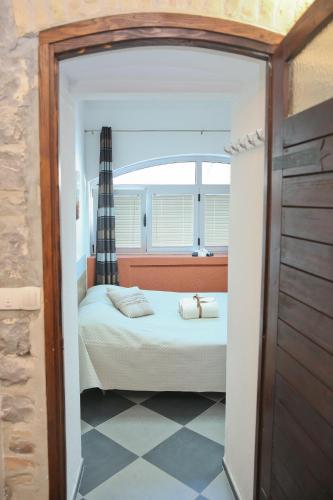 a small bedroom with a bed and a window at Apartments Qualitas in Kotor