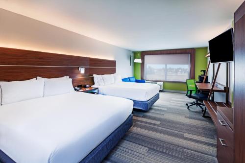 a hotel room with two beds and a desk at Holiday Inn Express & Suites Tulsa West - Sand Springs by IHG in Sand Springs