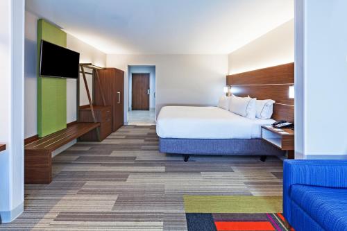 a hotel room with a bed and a flat screen tv at Holiday Inn Express & Suites Tulsa West - Sand Springs, an IHG Hotel in Sand Springs