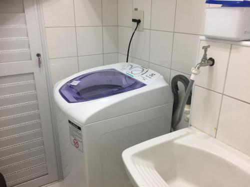 a washing machine in a bathroom with a sink at Vista ao Mar & Lazer Total in Guarujá