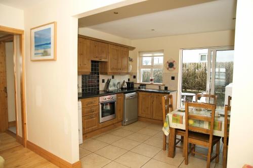 a kitchen with wooden cabinets and a table and a dining room at 10 Beachview in Duncannon