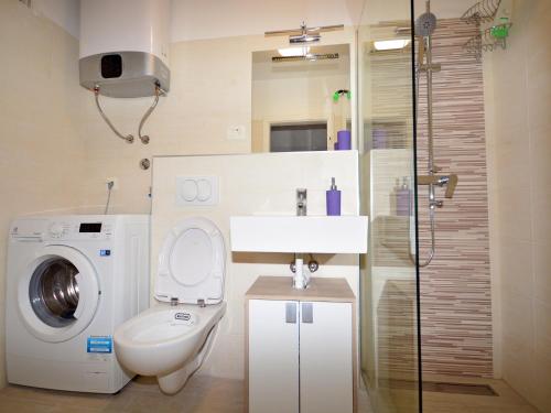 a bathroom with a washing machine and a toilet at Apartment Maria in Omiš
