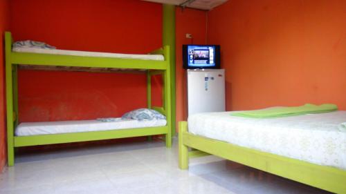 a room with two bunk beds and a television at Cabañas Ecoturisticas Y Club Gaira Tayrona in Santa Marta