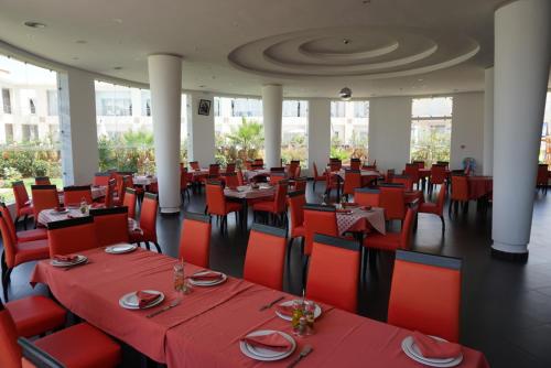 Sun Beach Med في السعيدية: مطعم بالطاولات الحمراء والكراسي الحمراء