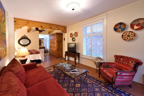 a living room with a red couch and a tv at Casa Culinaria - The Gourmet Inn in Santa Fe